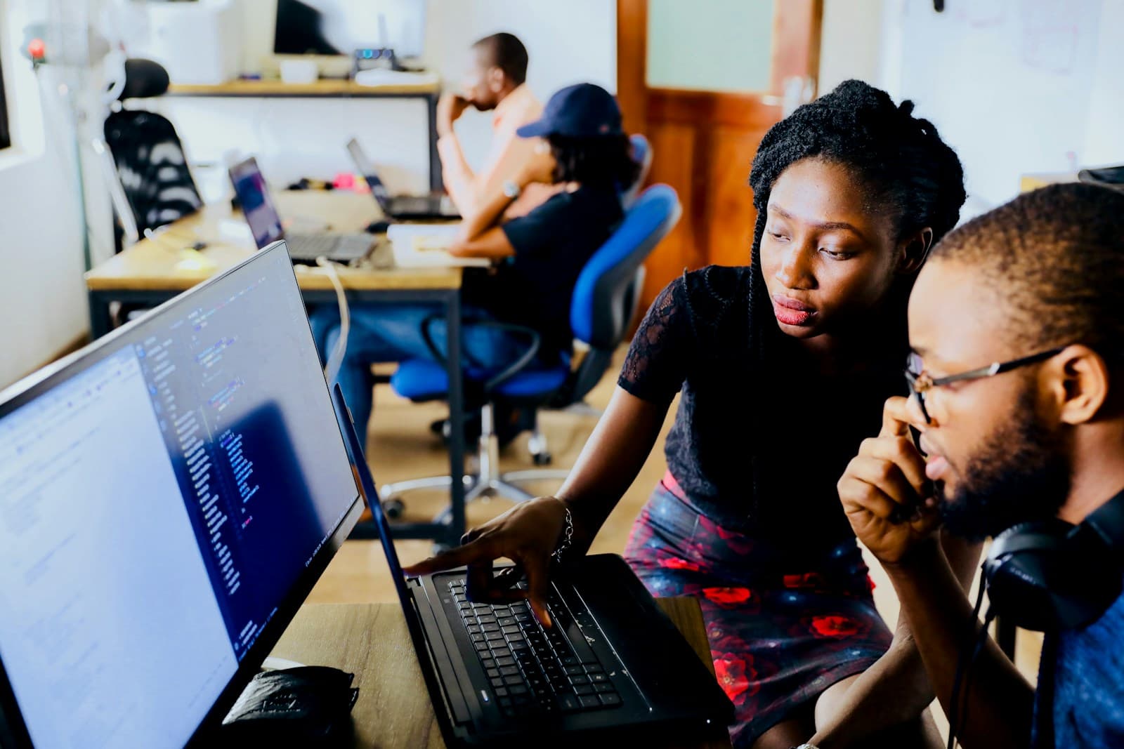 Support team members working through a customer issue together at a workstation